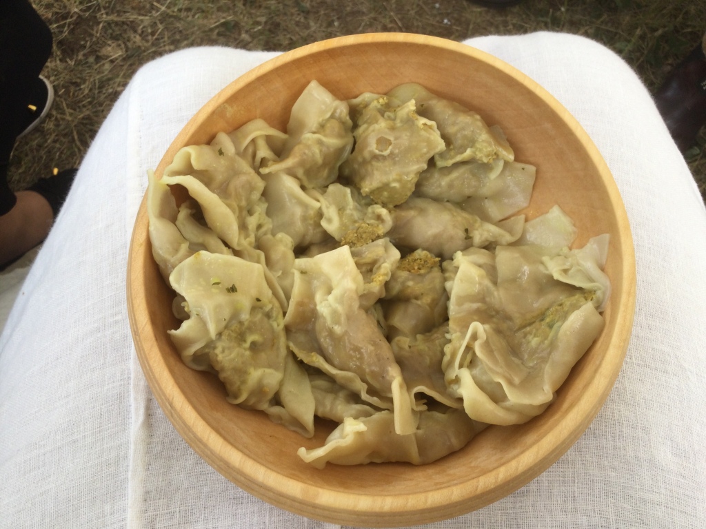 A wooden plate filled with chicken dumplings.